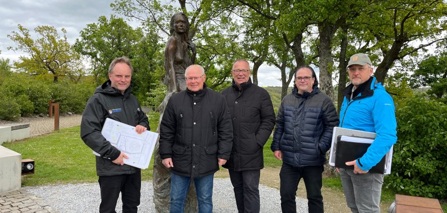 Es sind die im Text genannten Personen zu sehen, die vor der Loreley-Statue im Kultur- und Landschaftspark Loreley stehen.