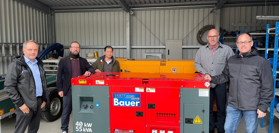 Bürgermeister Mike Weiland, Stefan Weidenbach (stellvertretender Werkleiter Loreley), Johannes Koziol (kaufmännischer Werkleiter Nastätten), Ralf Solinski (technischer Werkleiter Nastätten) und Bürgermeister Jens Güllering stehen neben den beschafften Notstromaggregaten. 