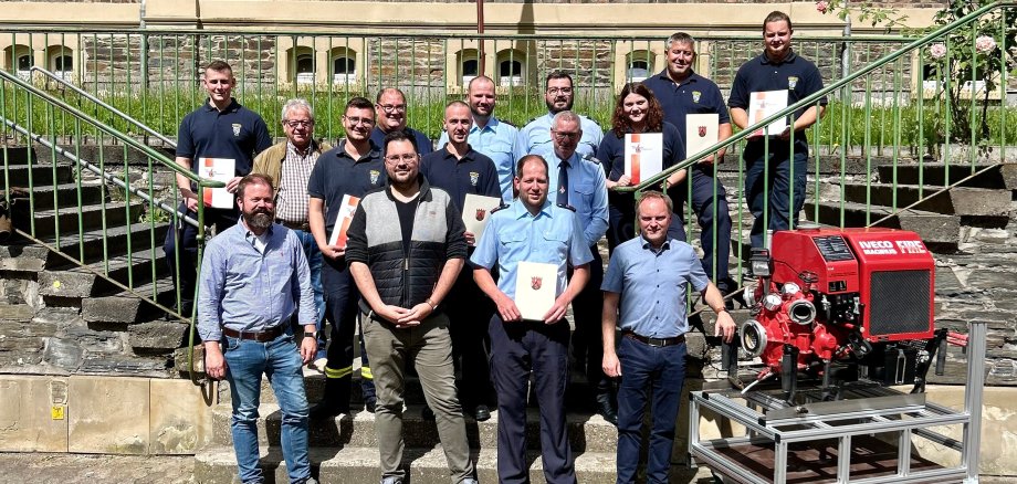 Das Bild zeigt die geehrten und beförderten Kameradinnen und Kameraden samt Wehrleitung und Bürgermeister Mike Weiland beim Gerätehausfest in Kaub.